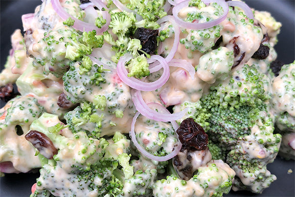 Cool Broccoli salad with red onions, raisins and a mayo dressing made with Pepperdrop Mustard. 