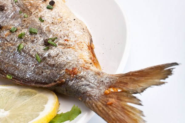 The tail of a fine little white fish grilled with a  garlic butter and White & Green Pepper basting sauce